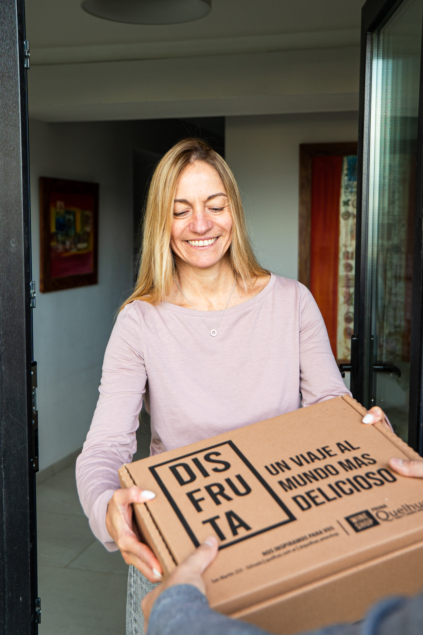 Una persona recibe el box de Vinito Q en su casa